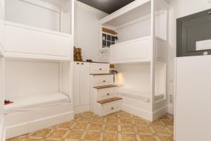 a white walk in closet with white cabinets at Casa Gracia in Barcelona