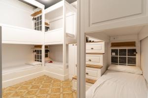 - une chambre avec des lits superposés et des armoires blanches dans l'établissement Casa Gracia, à Barcelone