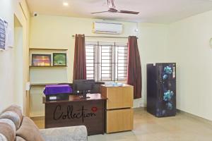 uma sala de estar com um sofá, uma mesa e um frigorífico em Hotel Orchid Residency Medavakkam em Chennai