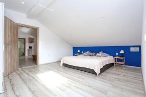 sypialnia z łóżkiem i niebieską ścianą w obiekcie Apartmani Natali w mieście Zadar