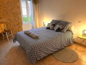 um quarto com uma cama com almofadas em La Maison Bleue em Sarlat-la-Canéda