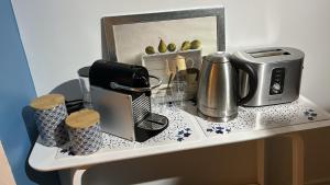uma bancada com comodidades para preparar café e uma torradeira em La Maison Bleue em Sarlat-la-Canéda