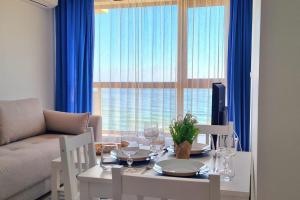 una sala de estar con una mesa y un sofá en Sea view 2, en Varna