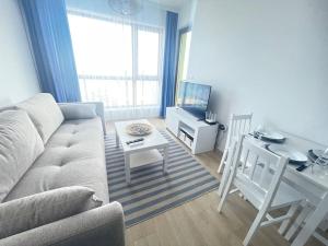 Una sala de estar con un sofá, una mesa y un escritorio. en Sea view 2, en Varna