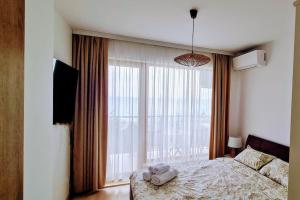 Un dormitorio con una cama y una ventana grande en Sea view 2, en Varna