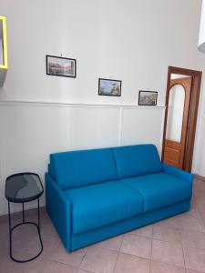 Sofá azul en la sala de estar con taburete en La Casa di Ivan e Giorgia, en Pozzuoli 28 fotos más