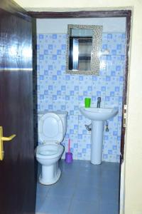 uma casa de banho com um WC e um lavatório em GARDEN INN by AIRPORT inn ltd em Kigali