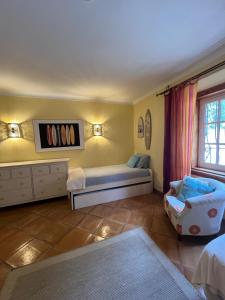 a bedroom with a bed and a chair and a window at Villa Malveira in Alcabideche +31 photos