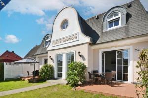 ein weißes Haus mit einem Tisch davor in der Unterkunft Haus Usedom Appartement Meeresklang in Ostseebad Koserow