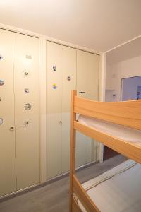 - une chambre avec des casiers blancs et des lits superposés dans l'établissement L'Ourson Randonneur - Station de ski à 600m, à La Bresse
