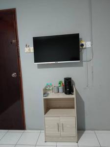 einen Flachbild-TV, der an einer Wand hängt in der Unterkunft Hotel Iramanis in Lahad Datu