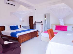 坦加拉的住宿－Sea Bay Inn Tangalle，一间带两张床和一张沙发的卧室