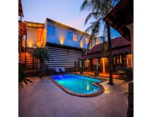 a swimming pool in front of a house at R K Habbana Beach Resort, Baga, Goa in Baga