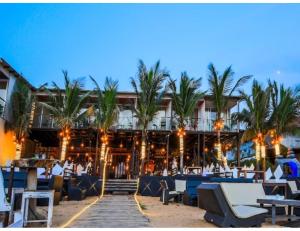 een hotel op het strand met palmbomen en stoelen bij R K Habbana Beach Resort, Baga, Goa in Baga
