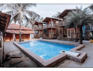 a large swimming pool in front of a house at R K Habbana Beach Resort, Baga, Goa in Baga