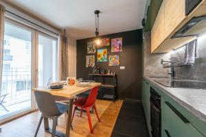 a kitchen with a wooden table and red chairs at L'Œuvre dArt - Appartement avec parking privé in Noisy-le-Grand