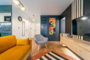 a living room with a yellow couch and a chair at L'Œuvre dArt - Appartement avec parking privé in Noisy-le-Grand