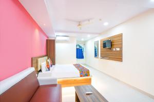 a hotel room with a bed and a couch at FabHotel Prime SYN Grand in Hyderabad