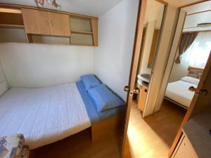 a small bedroom with a small bed and a door at Camping Mayer in Cavallino-Treporti