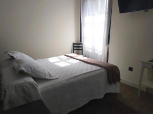 a bed in a room with a window and a bedspread at Hotel Villa Marrón in Naves