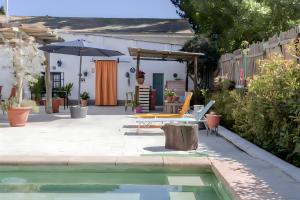 einen Hinterhof mit Pool und Sonnenschirm in der Unterkunft Casa Grande con piscina para familias in Granada