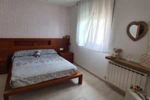 Schlafzimmer mit einem Bett und einem Wandspiegel in der Unterkunft Can Tete in Malgrat de Mar