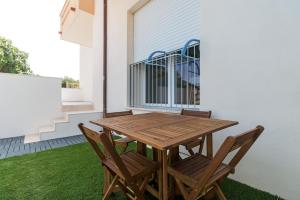 un tavolo e sedie in legno sul lato di una casa di Appartamento Perla Verde, WiFi e Air Con a Cala Gonone