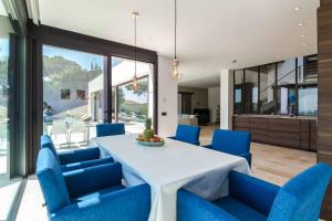 uma sala de jantar com uma mesa branca e cadeiras azuis em Villa Rosalicia em Tossa de Mar