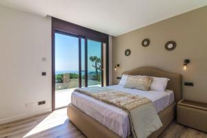 um quarto com uma cama grande e uma janela grande em Villa Rosalicia em Tossa de Mar