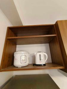 a microwave and toaster sitting on a wooden shelf at Jena Staycation in Lapu Lapu City
