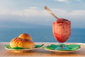 two plates of fruit and a drink on a table at New Naxos Village in Giardini Naxos