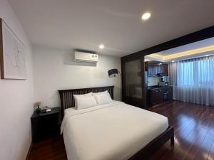 1 dormitorio con 1 cama blanca grande y cocina en BEU Home NN Hotel en Hanoi