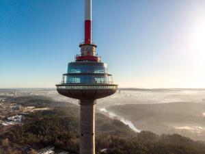 a observation tower on top of a hill with a view at Vilnius TV Tower Apartments DEBESYS in Vilnius