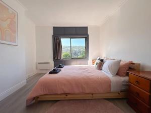a bedroom with a large bed with a window at Wellesley Mountain House near City in Hobart