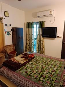 een slaapkamer met een bed en een televisie en gordijnen bij Blue Diamond Guest House in Pune