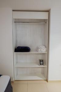 a white closet with white shelves and towels at Hotel Renty Beach in Encarnación
