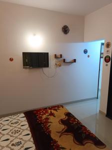 um quarto com uma televisão numa parede com um tapete em Blue Diamond Guest House em Pune