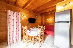 ein Esszimmer mit einem Tisch und einem Kühlschrank in der Unterkunft Gîte Tournette in Thônes