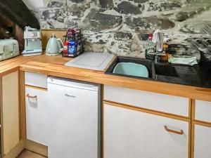 a kitchen with a sink and a counter at Top Cottage in Barmouth