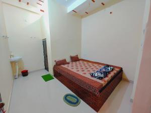 a bedroom with a bed in a white room at Aayu Parth Residency 300 M from Ram Janam Bhumi in Ayodhya