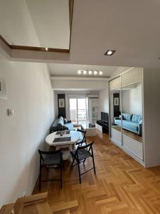 ポドゴリツァにあるStylish_apartmentのテーブルと椅子とベッドのあるリビングルーム