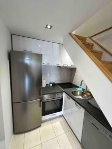 ポドゴリツァにあるStylish_apartmentのステンレス製の冷蔵庫とシンクを備えたキッチン