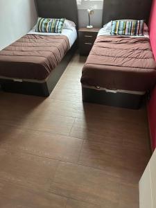 Pokój z 2 łóżkami i drewnianą podłogą w obiekcie Comfortable house w mieście El Prat de Llobregat