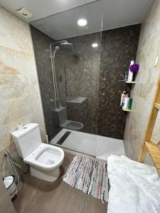 a bathroom with a white toilet and a shower at Comfortable house in El Prat de Llobregat