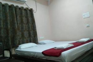 a bed in a room with a curtain at Hotel Jai Palace Wardha in Wardha