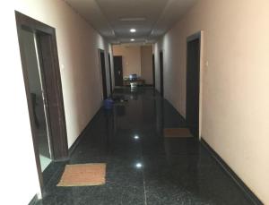 a hallway of a hotel with black floors and doors at Hotel Jai Palace Wardha in Wardha
