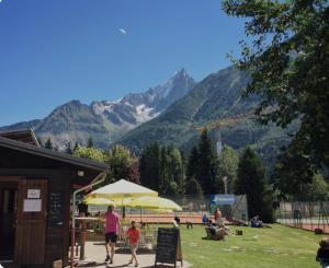 a woman and child walking in a park with mountains in the background at Andro in Chamonix