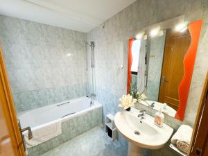 ein Badezimmer mit einer Badewanne, einem Waschbecken und einer Badewanne in der Unterkunft Escultor del Pilar ComoTuCasa in Saragossa