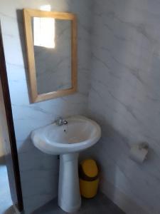 bagno con lavandino bianco e specchio di Recanto do Meu Tio a Chimoio