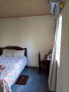 a bedroom with a bed and a table and a window at Recanto do Meu Tio in Chimoio